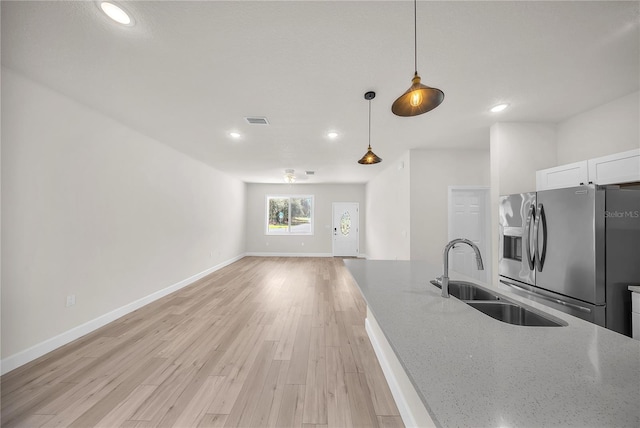 kitchen featuring a sink, visible vents, light wood-style floors, stainless steel fridge with ice dispenser, and pendant lighting