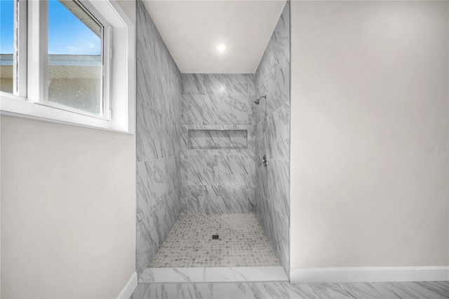 bathroom featuring marble finish floor, recessed lighting, a tile shower, and baseboards