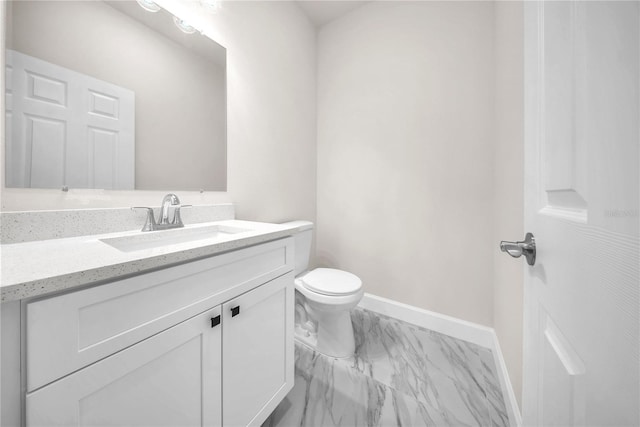 bathroom with toilet, marble finish floor, baseboards, and vanity