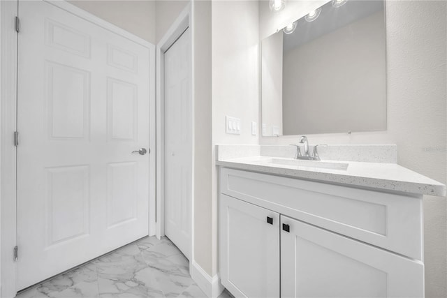 bathroom with marble finish floor and vanity