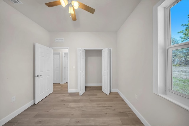 unfurnished bedroom with light wood finished floors, ceiling fan, baseboards, and a closet