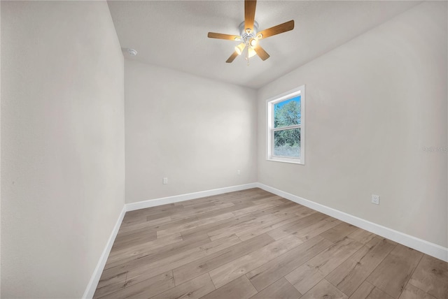 spare room with light wood-type flooring, ceiling fan, and baseboards