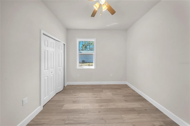 unfurnished bedroom with a ceiling fan, light wood-type flooring, a closet, and baseboards