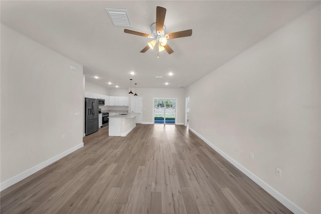 unfurnished living room with light wood-style flooring, recessed lighting, a ceiling fan, visible vents, and baseboards