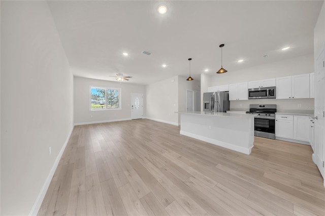 kitchen featuring light wood-style flooring, visible vents, open floor plan, light countertops, and appliances with stainless steel finishes