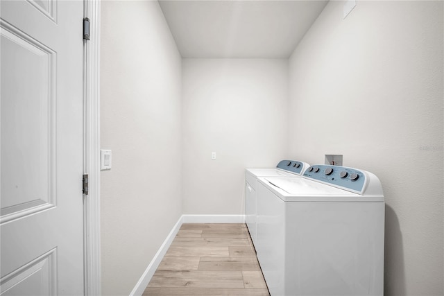 washroom with washer and dryer, laundry area, light wood-style flooring, and baseboards