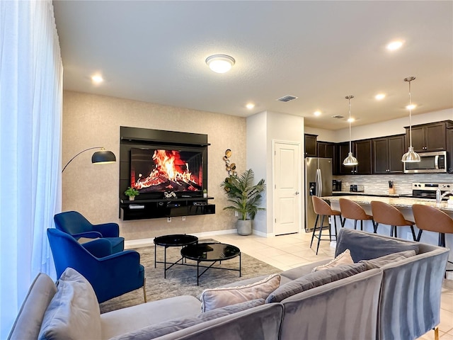 living room with light tile patterned floors, baseboards, a lit fireplace, and recessed lighting