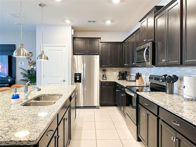 kitchen with visible vents, light stone counters, appliances with stainless steel finishes, light tile patterned flooring, and a sink