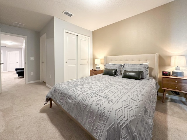 bedroom featuring light carpet, visible vents, baseboards, and a closet