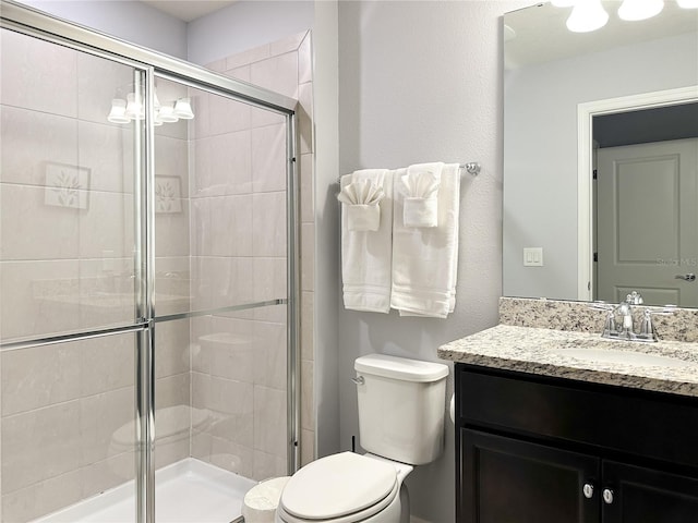 bathroom with vanity, toilet, and a shower with shower door