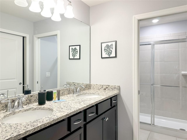 bathroom with double vanity, a stall shower, and a sink