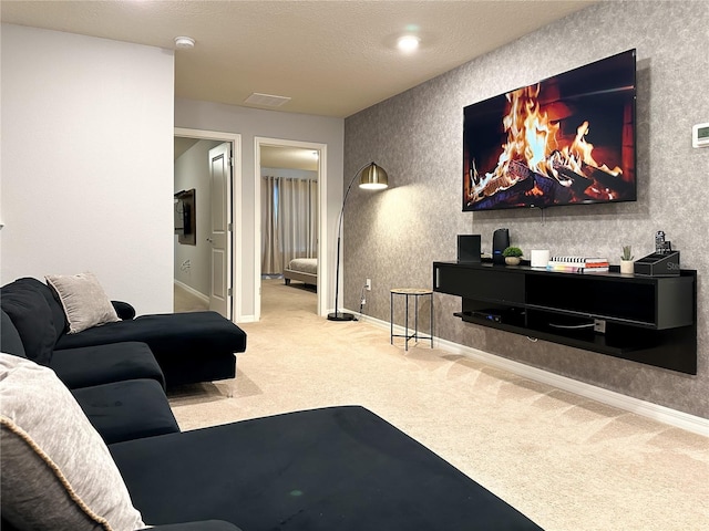 living area featuring baseboards, carpet floors, a textured ceiling, and visible vents