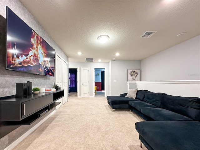 living area featuring recessed lighting, light colored carpet, visible vents, and a textured ceiling