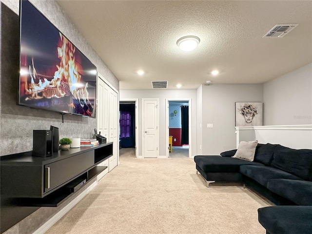 living room featuring light carpet, visible vents, recessed lighting, and a textured ceiling