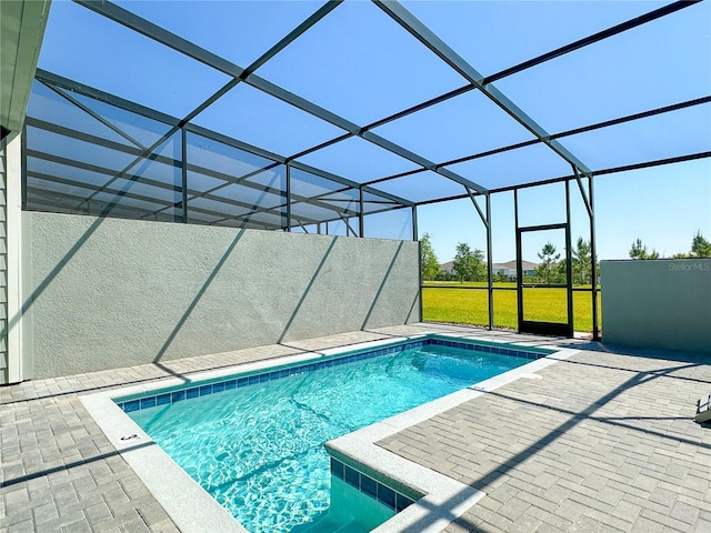 pool featuring glass enclosure and a patio area