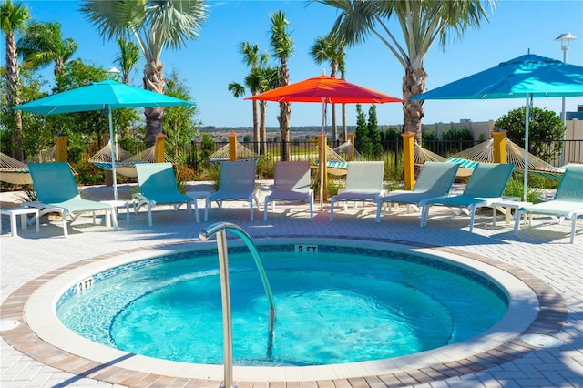 view of pool featuring a patio, fence, and a hot tub