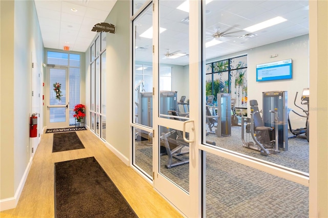 interior space featuring a drop ceiling, baseboards, visible vents, and wood finished floors