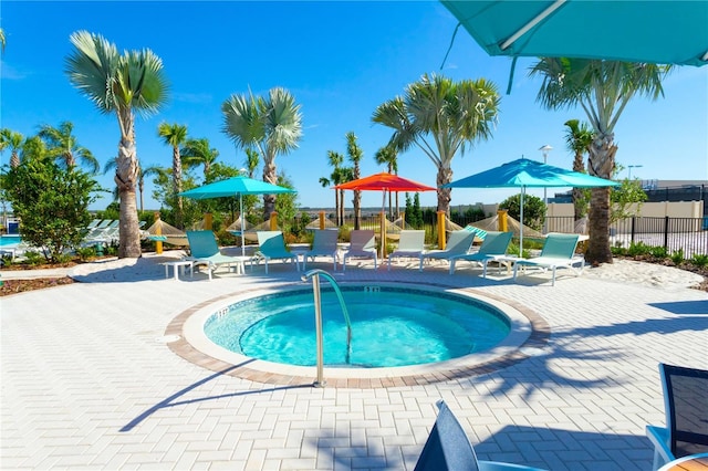 view of pool featuring a patio area, a community hot tub, and fence