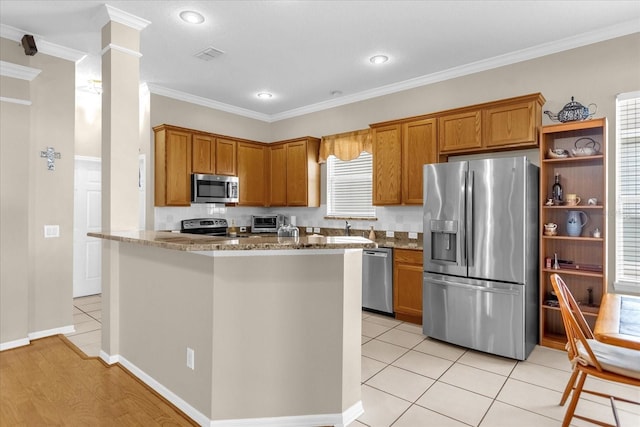 kitchen featuring light stone countertops, appliances with stainless steel finishes, a wealth of natural light, and ornamental molding