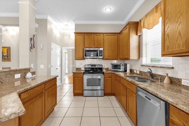 kitchen featuring sink, light stone countertops, stainless steel appliances, and ornamental molding