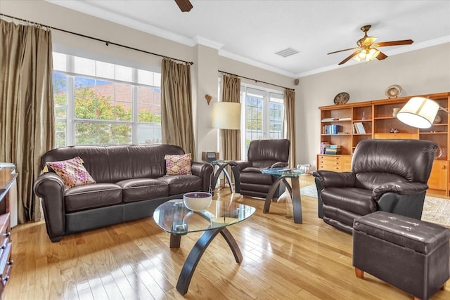 living room with crown molding, light hardwood / wood-style flooring, and ceiling fan