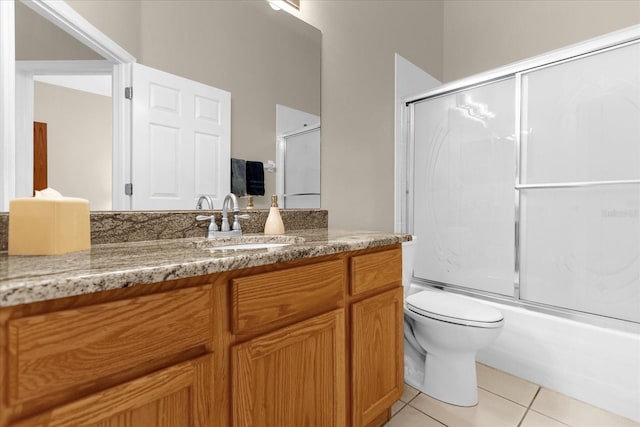 full bathroom with tile patterned floors, vanity, toilet, and shower / bath combination with glass door