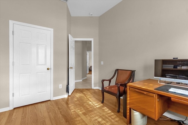 home office featuring light hardwood / wood-style floors and vaulted ceiling