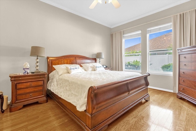 bedroom featuring ceiling fan, light hardwood / wood-style floors, and crown molding