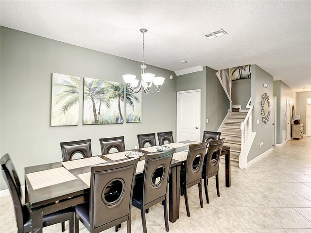 dining room with a textured ceiling, a notable chandelier, and light tile patterned flooring