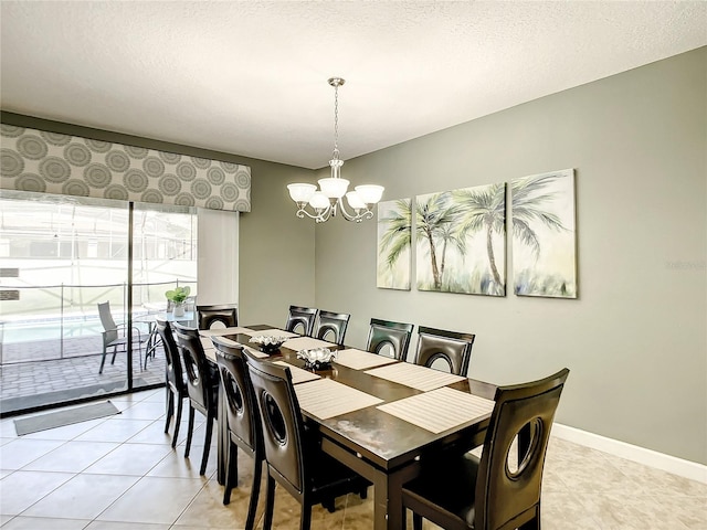 tiled dining room featuring a chandelier and a textured ceiling