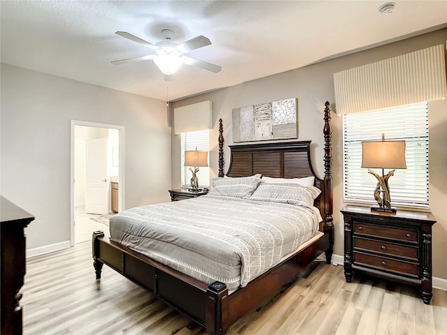 bedroom featuring ceiling fan, ensuite bath, and light wood-type flooring