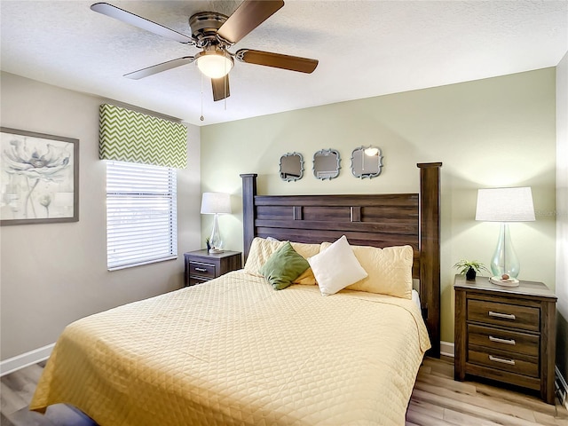 bedroom featuring ceiling fan, a textured ceiling, and light hardwood / wood-style flooring