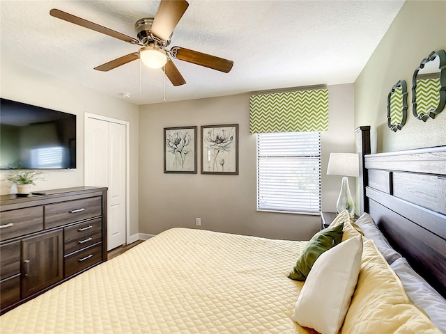 bedroom with a textured ceiling, ceiling fan, and a closet