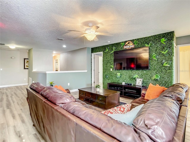 living room with hardwood / wood-style floors, ceiling fan, and a textured ceiling