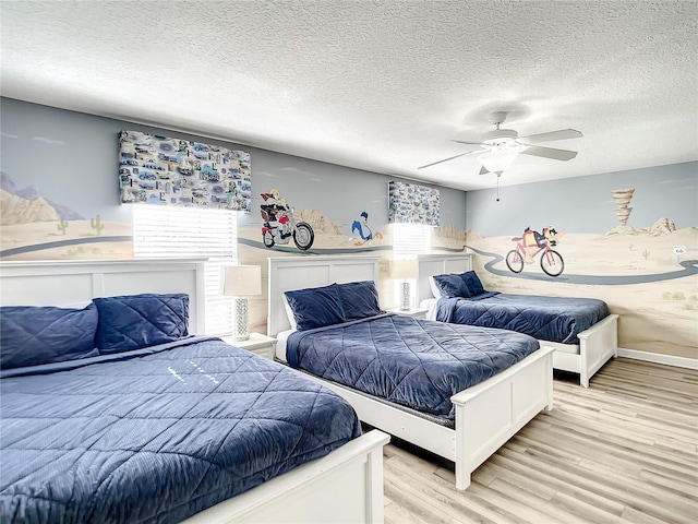 bedroom with a textured ceiling, ceiling fan, and light hardwood / wood-style floors