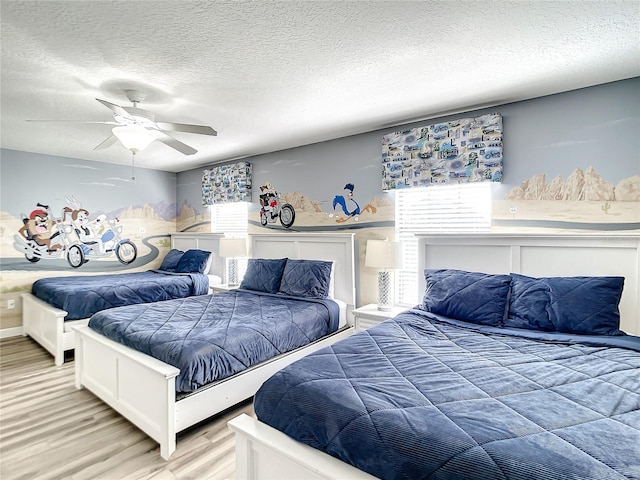 bedroom featuring a textured ceiling, ceiling fan, and light hardwood / wood-style floors