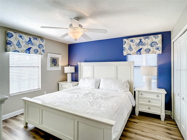 bedroom featuring light wood-type flooring, a closet, and ceiling fan