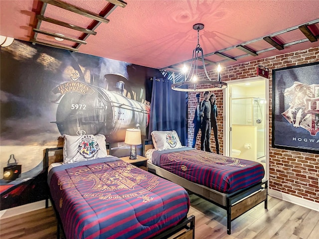 bedroom featuring hardwood / wood-style flooring, a textured ceiling, and brick wall