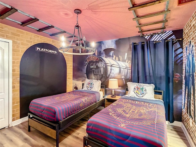 bedroom featuring hardwood / wood-style flooring and brick wall