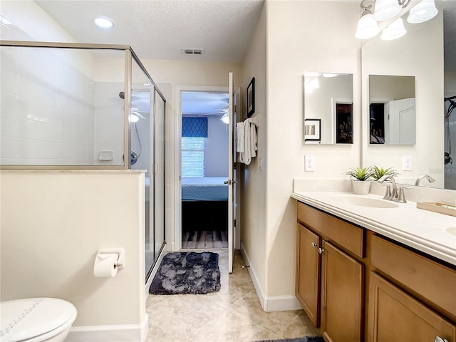 bathroom featuring vanity, toilet, walk in shower, and tile patterned floors