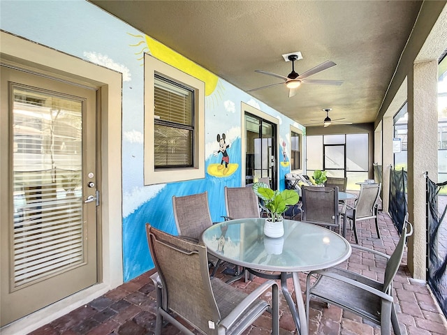 sunroom / solarium featuring ceiling fan