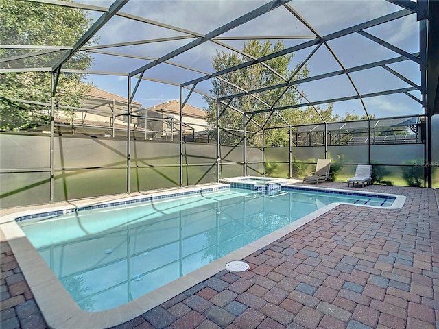 view of pool with an in ground hot tub, a patio, and a lanai