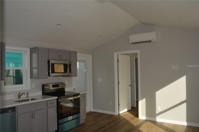 575 2nd St, Oviedo, FL 32765 - kitchen with an AC wall unit, dark hardwood / wood-style flooring, stainless steel appliances, sink, and vaulted ceiling
