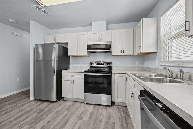 kitchen with stainless steel appliances, sink, and white cabinets