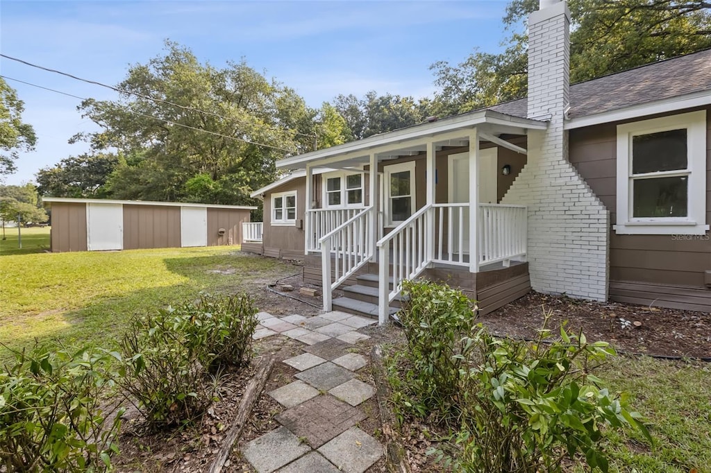 view of front of property featuring a front yard and a storage unit