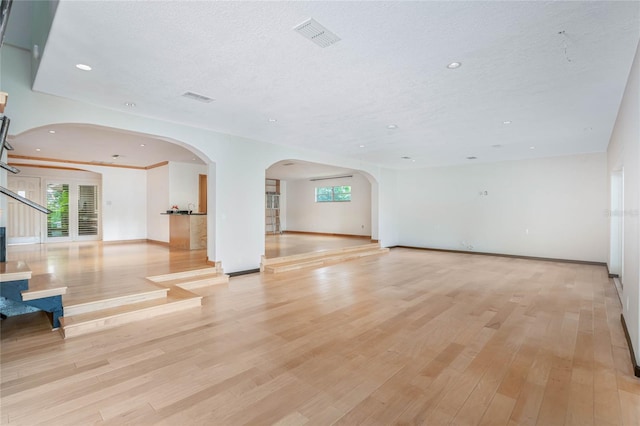 interior space featuring a textured ceiling, light wood-type flooring, and plenty of natural light