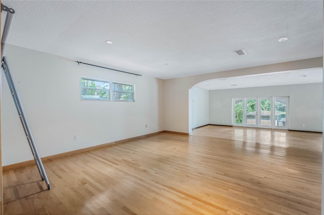 interior space featuring a textured ceiling and light hardwood / wood-style flooring