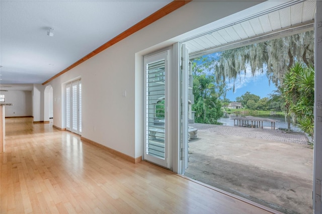 doorway to outside with crown molding and light hardwood / wood-style floors