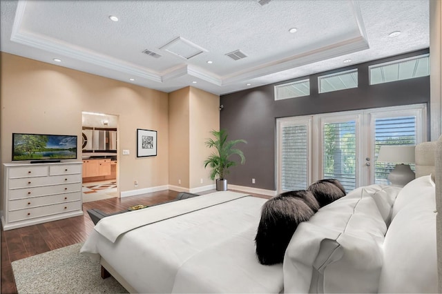 bedroom featuring a tray ceiling, a textured ceiling, dark hardwood / wood-style floors, access to outside, and connected bathroom