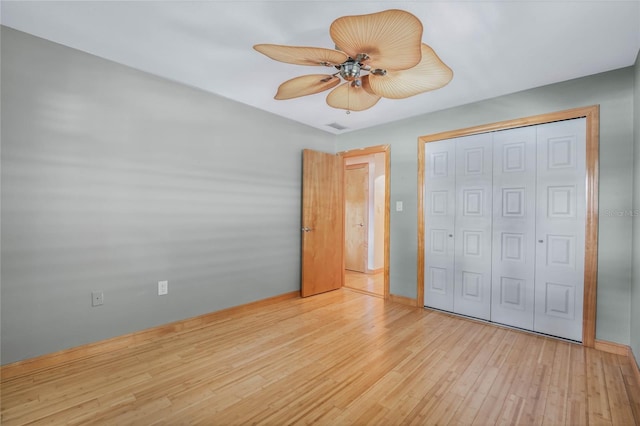 unfurnished bedroom with ceiling fan, light hardwood / wood-style flooring, and a closet